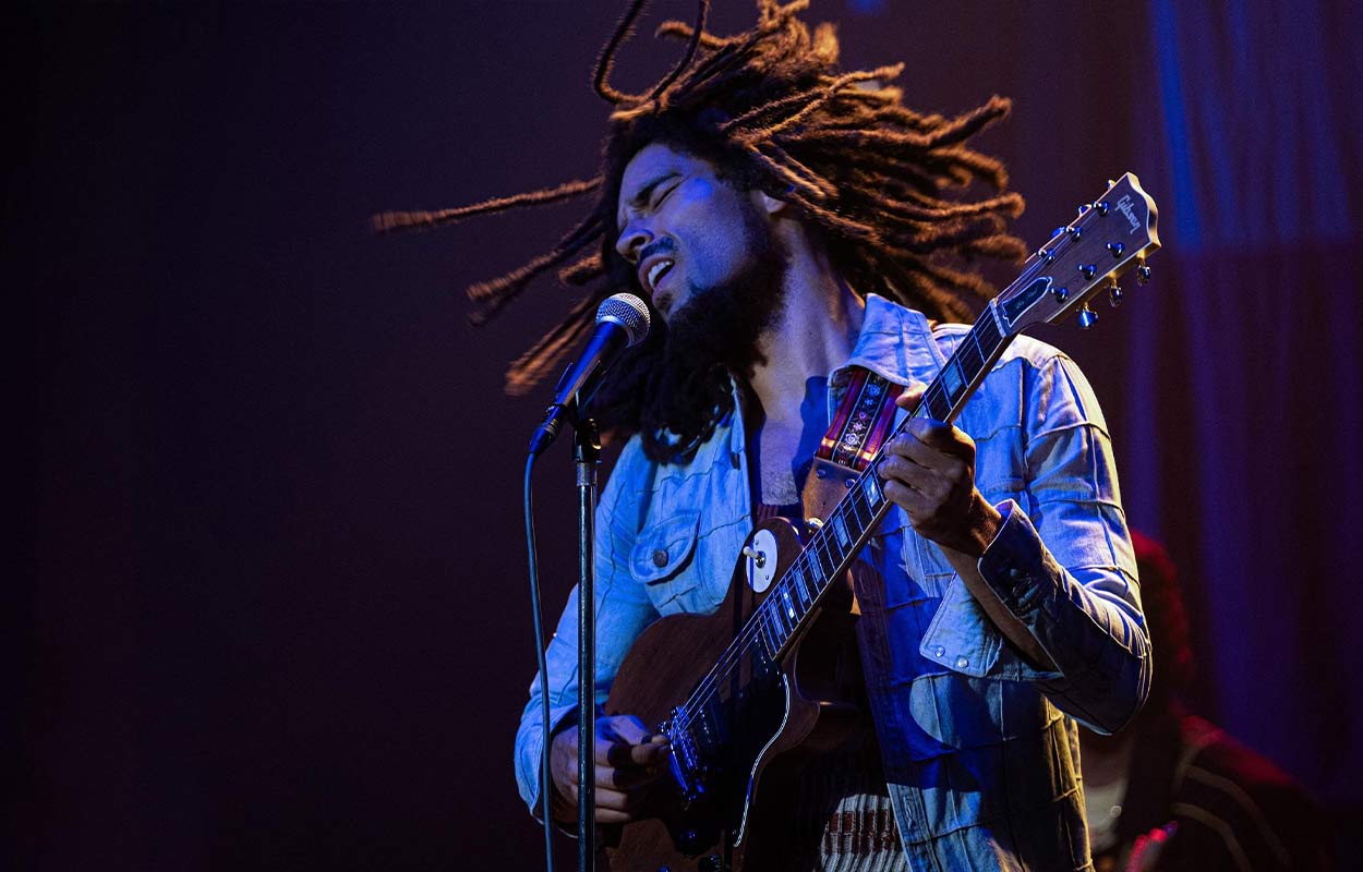 "Bob Marley" står på en scen och spelar gitarr.