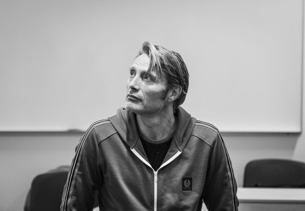 Mads Mikkelsen blickar upp mot taket.