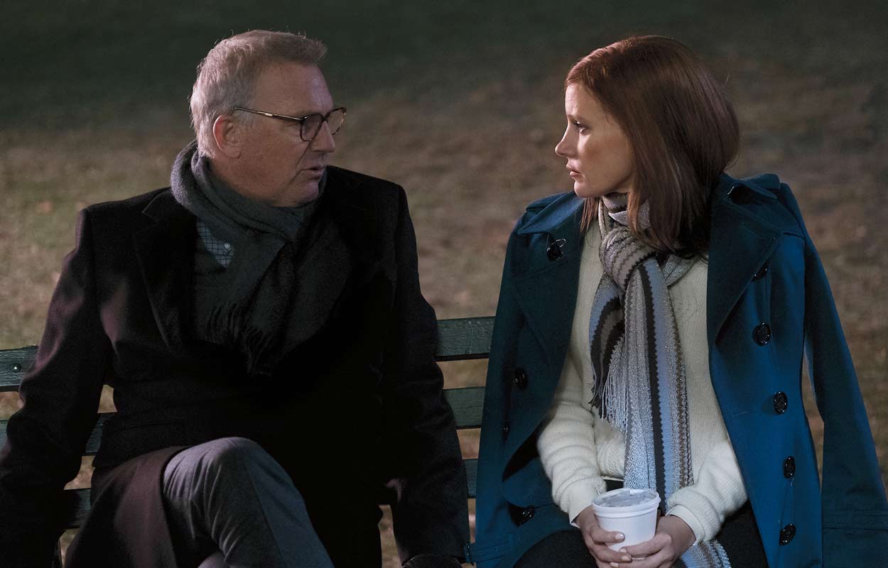 Kevin Costner och Jessica Chastain sitter på en bänk.